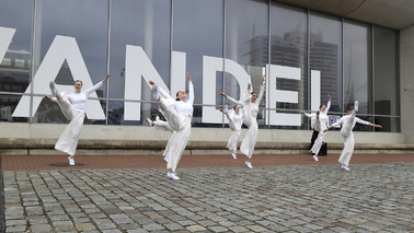 Weißgekleidete Tänzerinnen der Tanz-Etage vor dem Schriftzug "WANDEL" beim Deutschen Schifffahrtsmuseum