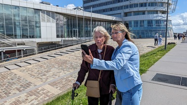 Zwei Frauen schauen auf die App "BremerhavenGuide"