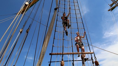 Two people climb into the rigging