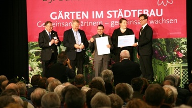 Fünf Männer mit Urkunden stehen auf der Bühne.