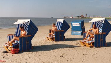 Four beach baskets are located in the sand area.