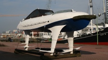 A boat with wings stands ashore.