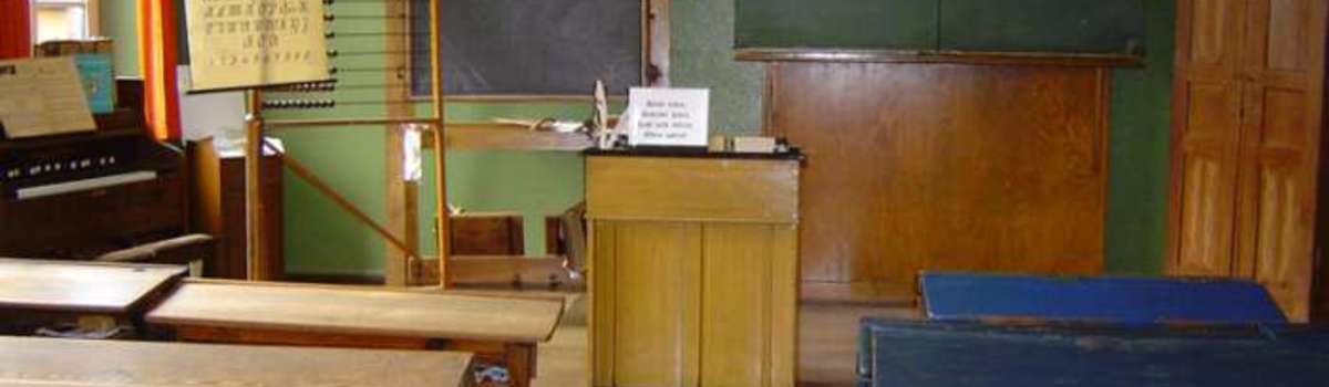 Classroom with teacher's desk and slateboard.
