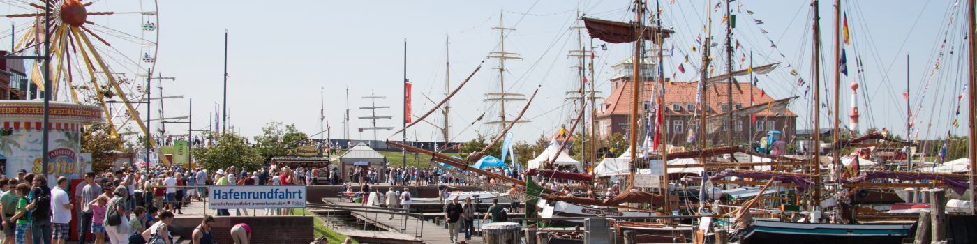 Viele Besucher auf einer Veranstaltung schlendern an Schiffen vorbei.