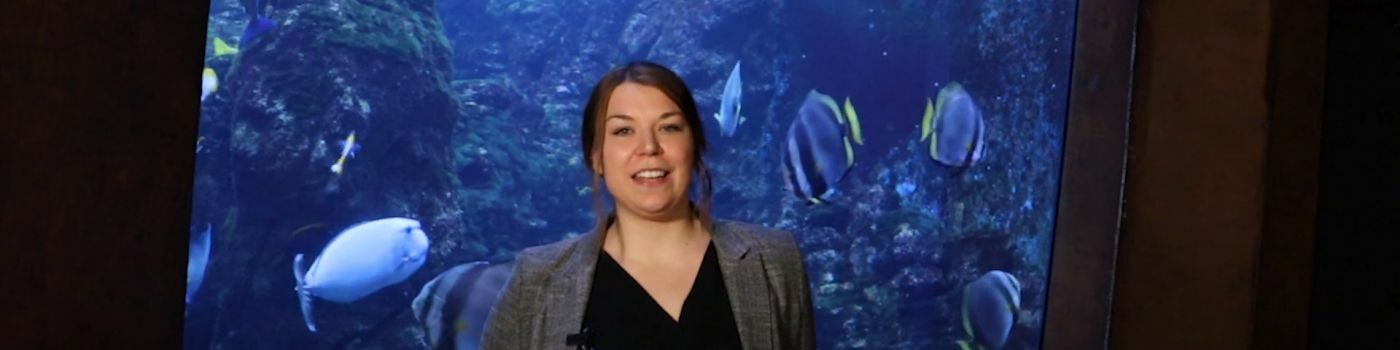 Eine junge Frau vor einem Aquarium.